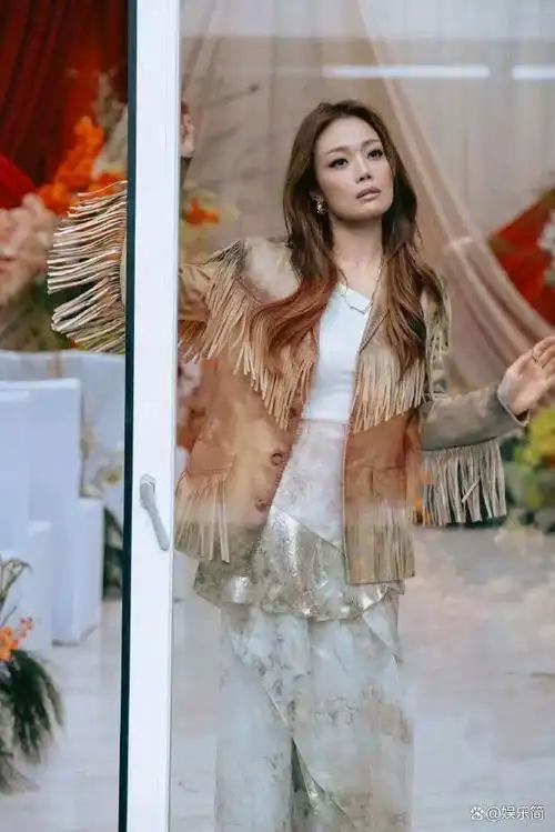 照片中,容祖儿身穿流苏外套搭配长裙,裙