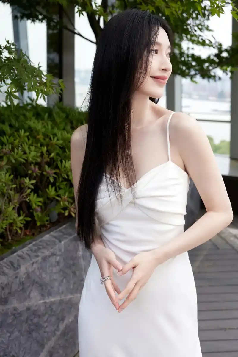 张俪着抹胸吊带白裙,展灵动之姿.