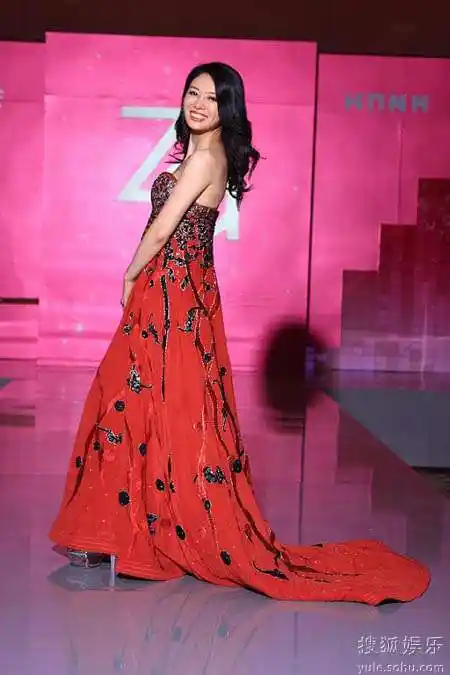 邓英笑容迷人近日,著名演员邓英现身某品牌发布会,一袭红色孔雀礼裙