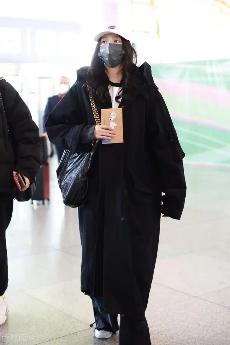关晓彤机场街拍,黑色风衣搭配黑色阔腿裤,头戴白色棒球帽潇洒大方!