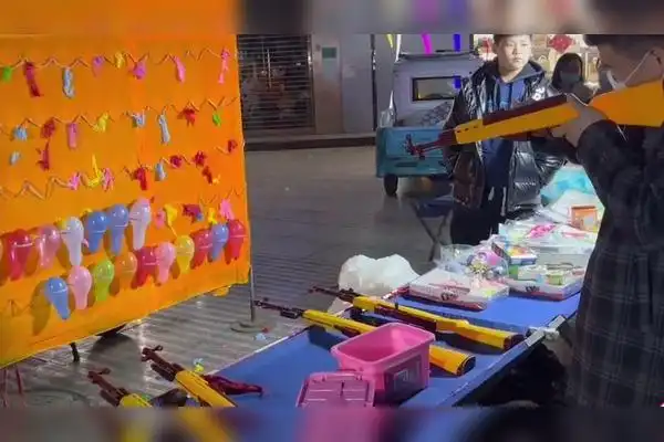 小伙街头用枪打气球百发百中动作犀利一旁老板心痛死了