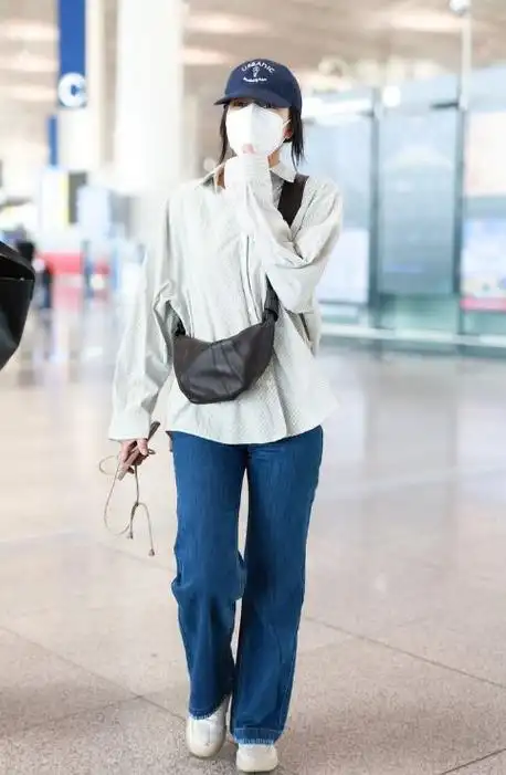 高圆圆上身穿浅色衬衣,下身搭配蓝色牛仔裤,展现出优雅随性的魅力,真