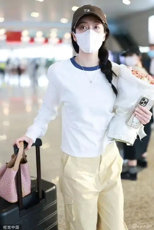 组图张雪迎手拿鲜花现身机场绑单侧麻花辫淑女风