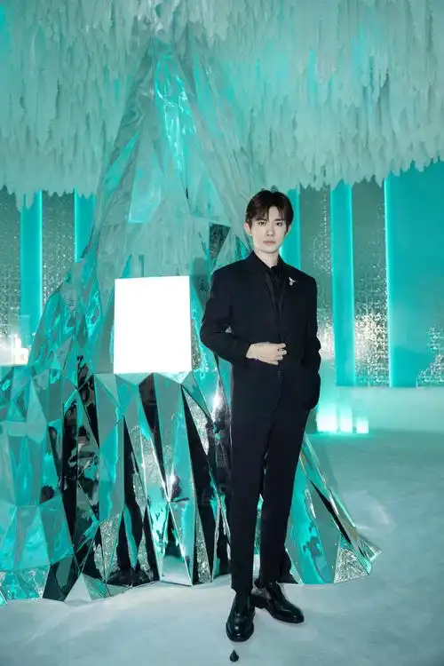 易烊千玺亮相品牌活动身着纯黑西装并造型点缀钻石鸟的胸针