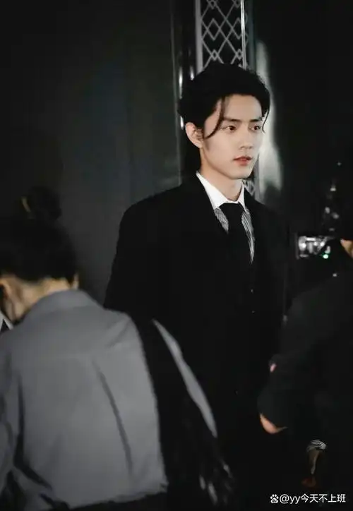 身穿标志性白色衬衣与黑色长裤,头发也梳成了狼尾大背头,优雅神秘的