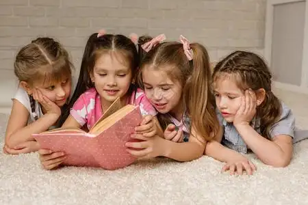 一群孩子躺在地板上阅读故事书四个小女孩一起在班上学图片