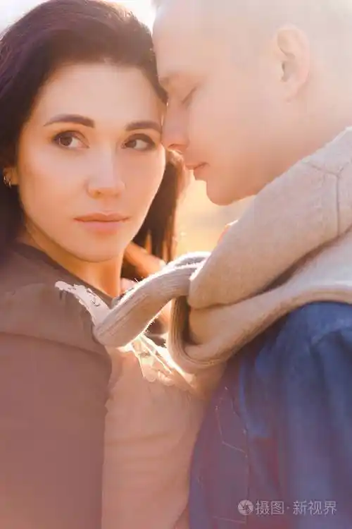 夕阳下的情侣时髦的男朋友和女朋友互相亲吻