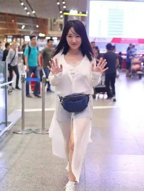 原创原创48岁杨钰莹丝毫不见老穿粉色薄纱裙走机场近照让人看了心动