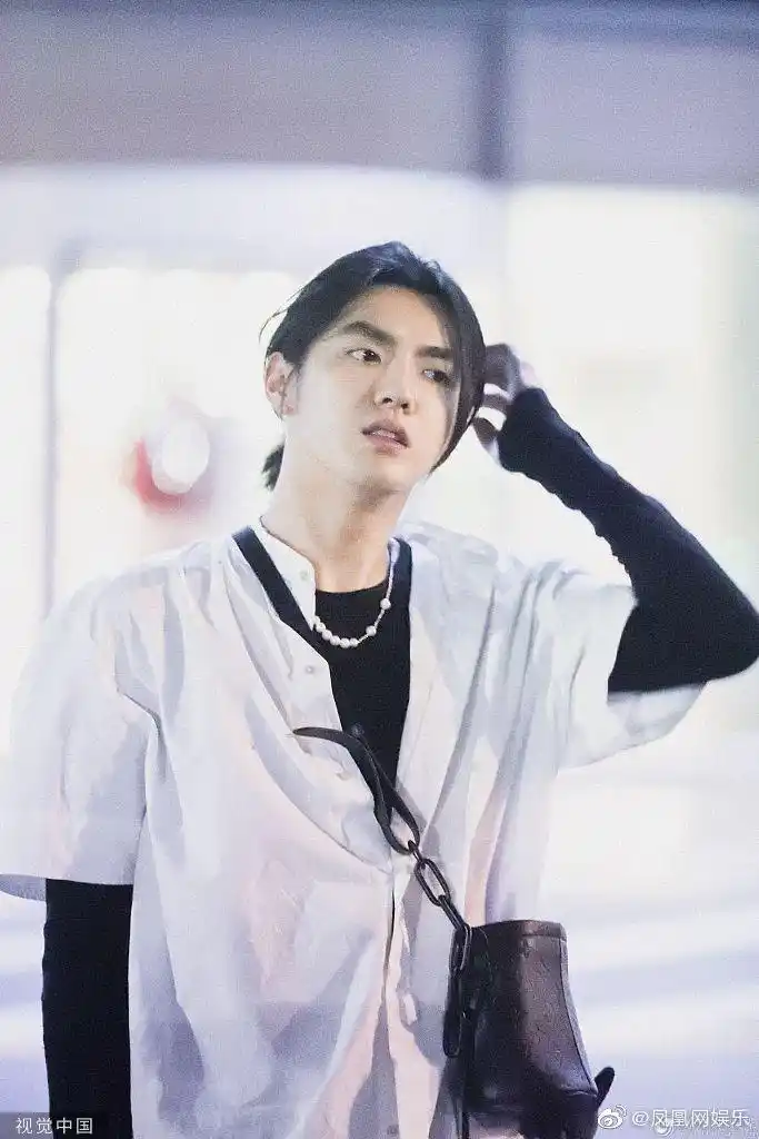 吴亦凡现身北京机场,帅气满分他一身黑白搭配,衬衫宽松,把长发扎成