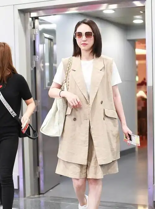 39岁董璇现身机场,白t恤配长马甲优雅干练,搭配五分裤清爽利落