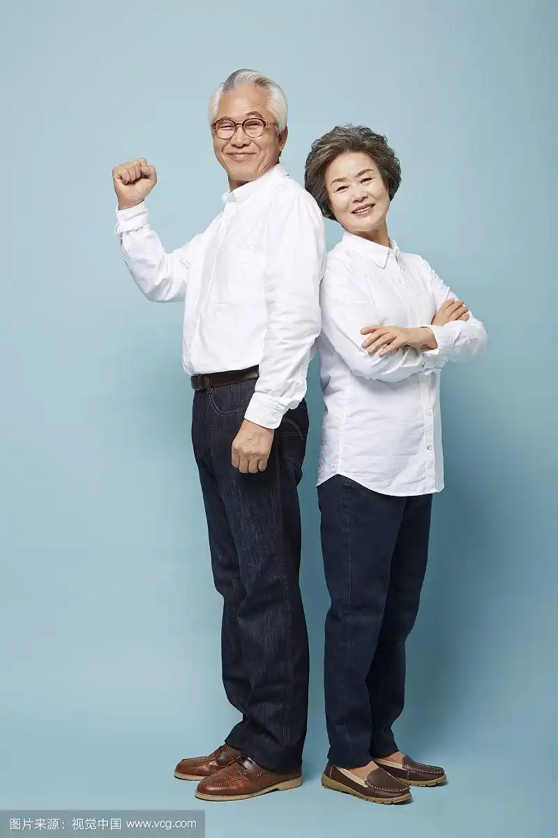 老夫妇背靠背微笑的照片
