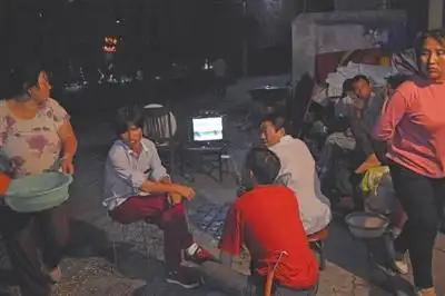 p>  夏日的夜晚,租住在民乐村的人们室外乘凉.(摄于2015年) /p>