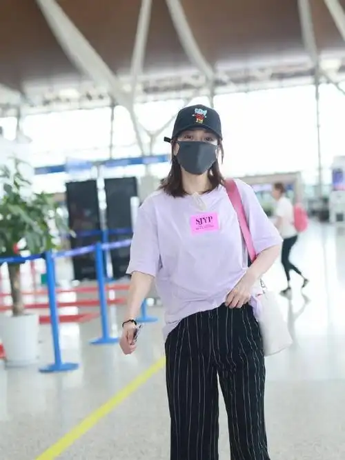 张靓颖素颜走机场,穿白色t恤搭格纹阔腿裤,活力清新哪像35岁?