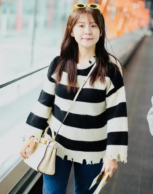 原创热依扎低调现身机场穿斑马毛衣配小黄帽憨态笑容难掩好心情