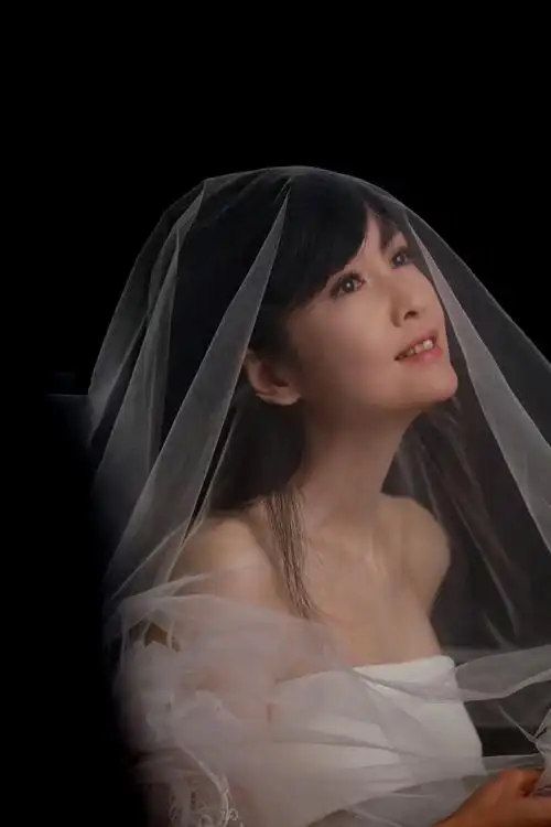 曝光的海报中周慧敏头披白纱,身穿露肩白色礼服,面露微笑,双手合十