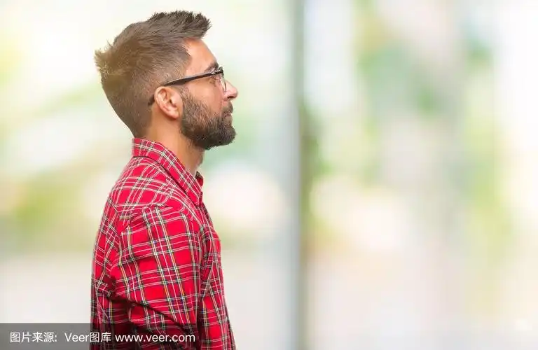成年西班牙男子戴眼镜孤立的背景看向一边,放松的侧面姿势与自然的脸