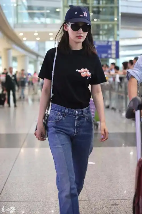 李沁戴墨镜穿黑色t恤搭配蓝色牛仔裤现身机场,皮肤白皙面带微笑