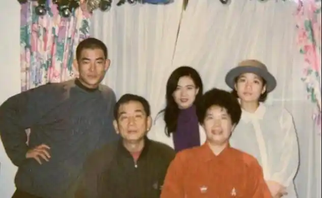 从照片中可以看出年轻时的任贤齐颜值超高,在父亲后面稍微斜着身子