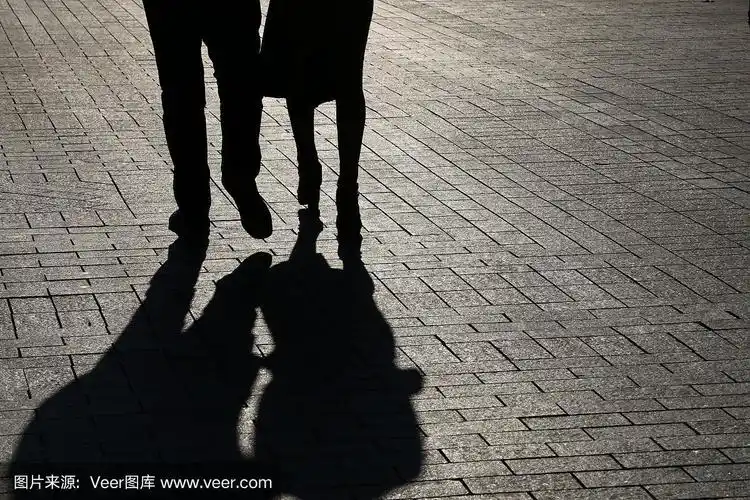 一对情侣走在街上的剪影和影子