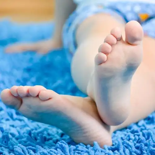 孩子的脚的特写,在蓝色的地毯上儿童脚的特写