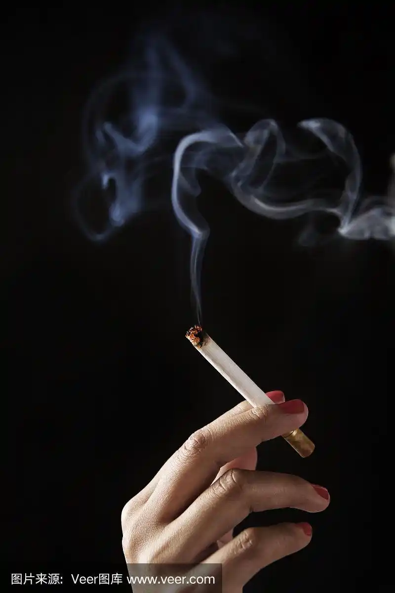 女性手指握着燃烧的香烟