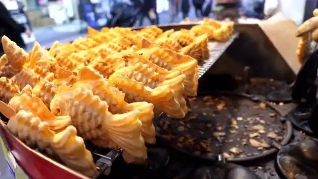 韩国街头美食烤鱼饼,鱼肉剁碎和面糊搅拌均匀灌在鱼形状模具里烤