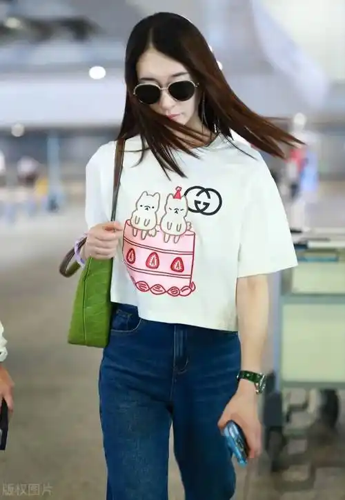 冷白皮的李小冉机场造型很清新,白色卡通t恤衫搭配蓝色牛仔裤,时髦