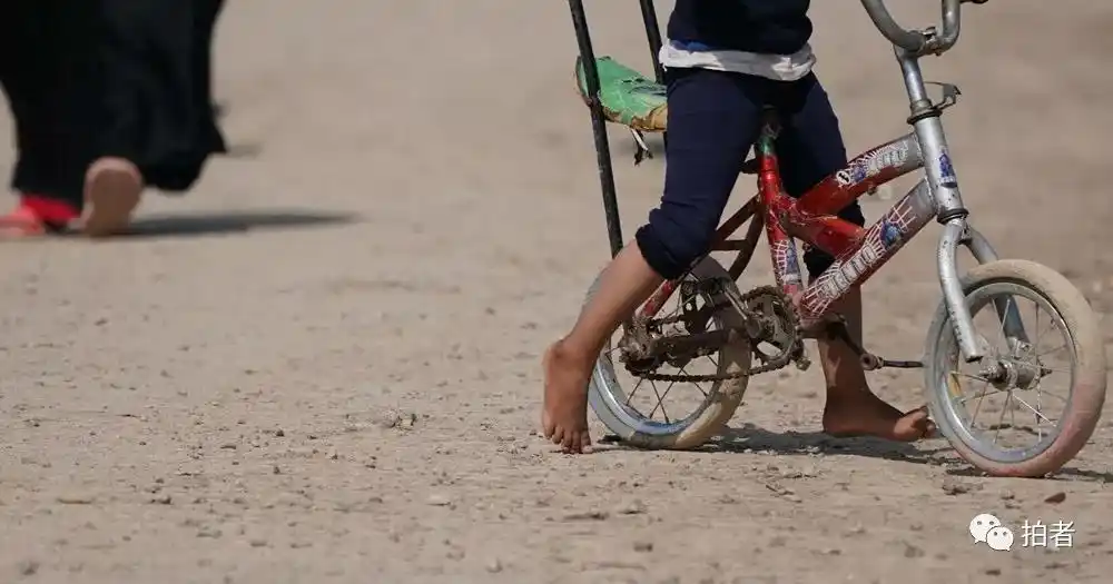 首都巴格达,当天近30摄氏度的高温,没有鞋子的孩子赤脚走在地面上