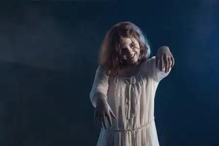 黑色背景恐怖片中穿着白色裙子的可怕女孩照片