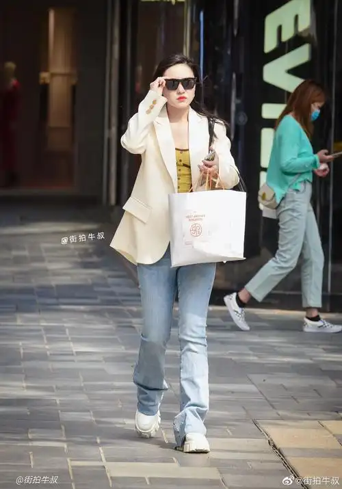 姑娘穿着漂亮的白色休闲西服出街