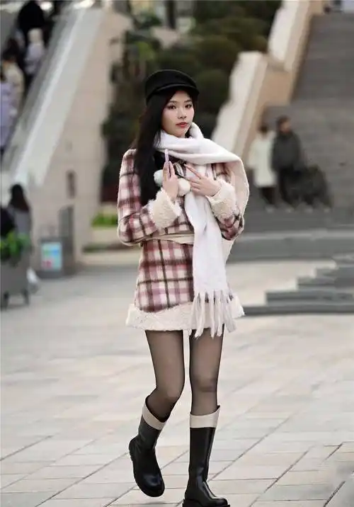 这个漂亮的女孩子,穿着一双黑色的长筒靴,厚跟的,鞋跟比较高,5厘米