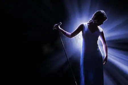 舞台上拿着话筒的女歌手.