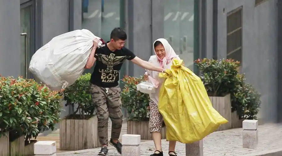 【当拾荒老人街头抬不动重物,有路人一把扛起这两个袋子!