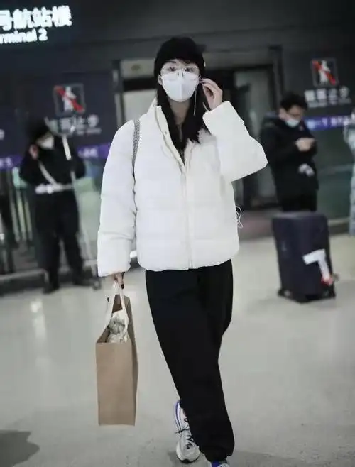 李菲儿冬天走机场都这么潮!白色棉服配黑卫裤不显臃肿,简约保暖