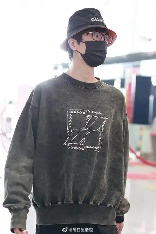 2022年4月9日,北京,许嵩穿墨绿色卫衣戴celine渔夫帽现身机场,帅气