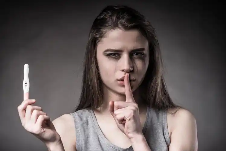 灰色背景下女人用嘘的手势拒绝堕胎烦躁恼火烦躁