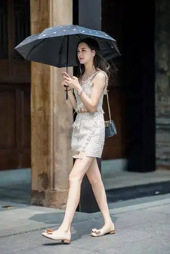街拍夏日街头的美女皮肤白皙一件吊带裙时尚中透露出一丝性感