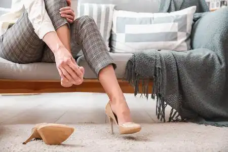 年轻女子在家穿高跟鞋感到疼痛照片
