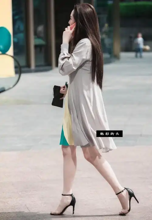 穿连衣裙,高跟凉鞋的美女身材高挑, 打着电话疾驰而过