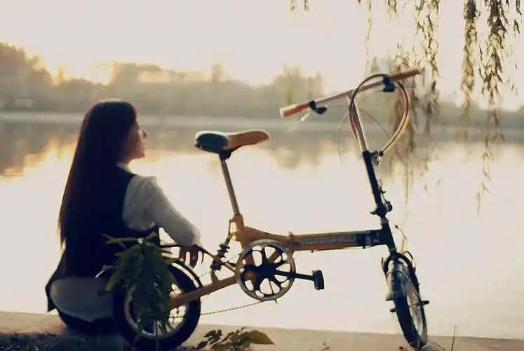 图片一个女孩坐着的背影旁边有个自行车
