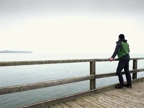 独自一人在扶手的男人,秋雾的早晨,在海码头.抑郁