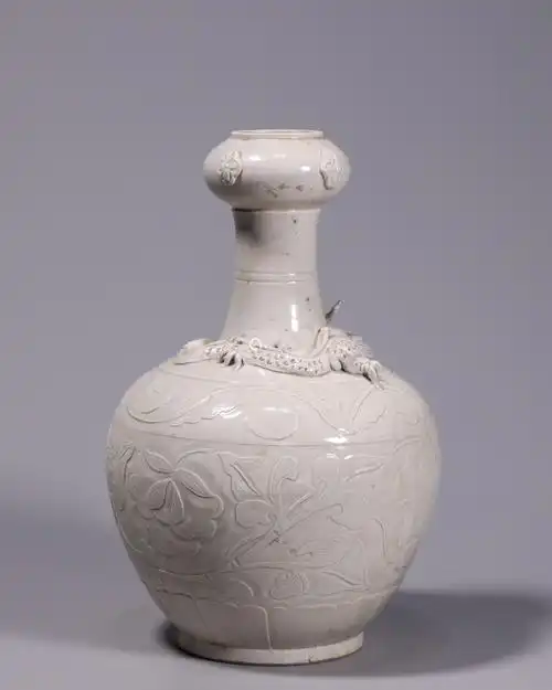 定窑白釉剔刻花卉堆塑龙纹蒜头瓶