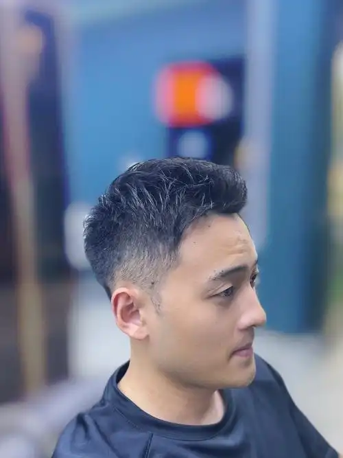 整体头发长度较短,顶部头发微微向上翘起,形成自然的前刺效果,鬓角和