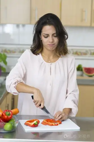 年轻漂亮的女人切蔬菜