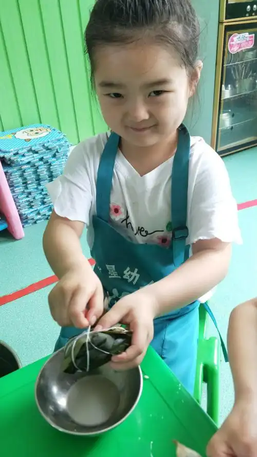 童星幼儿园【棕香飘扬】中一班端午节的包粽子活动
