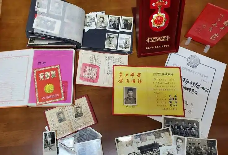 他身穿军装的照片外,还放了他十分"宝贝"的物件:光荣证,军校毕业证书