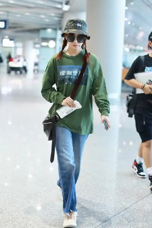 近日赵薇现身机场,她头戴绿色渔夫帽,扎着两个麻花辫,造型青涩少女感
