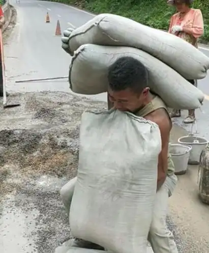 肩膀上扛的是责任,嘴里咬的是爱情,小伙儿肩扛两袋水泥嘴叼一袋