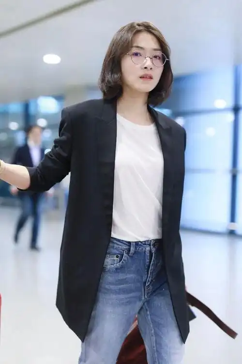 万茜穿黑色宽松西装配牛仔裤现身自推行李行走秀大长腿星范十足