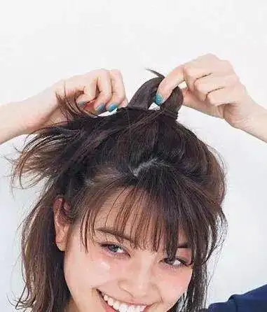 第二步:接着用橡皮筋将头发扎成丸子头形状,注意是最后一圈橡皮筋的